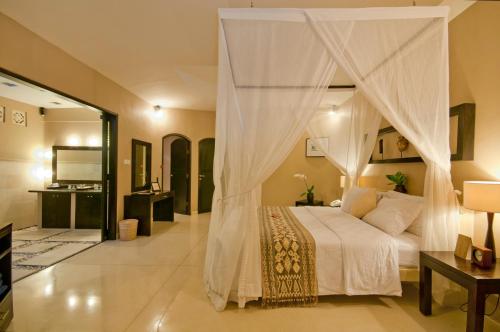 塞米亚克杜顺酒店的一间卧室配有一张带天蓬的床