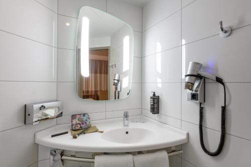 吕贝克吕贝克市宜必思酒店的白色的浴室设有水槽和镜子