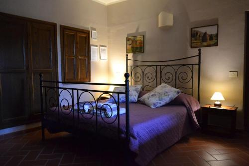 CantagalloAgriturismo Selvapiana的一间卧室配有一张带紫色床单和灯的床