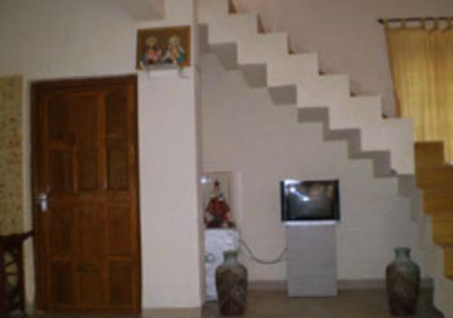 阿利鲍格Drisl Villa 3BHK的一间设有楼梯、电视和门的房间