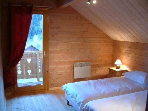 Saint-Pancrace索里尔及度假公寓式酒店的一间卧室设有两张床和窗户。