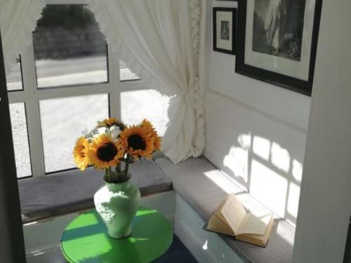 法尔茅斯Rosemullion Hotel的窗户前的桌子上带向日葵的花瓶