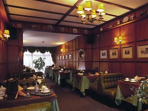 法尔茅斯Rosemullion Hotel的一间带桌椅和吊灯的用餐室