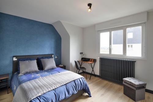 圣马洛Le MoZen - Appartement proche hippodrome - St Malo的一间卧室设有一张蓝色墙壁的大床