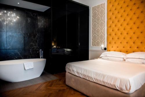 罗马Boutique Centrale Palace Hotel的一间卧室设有一张大床和一个浴缸
