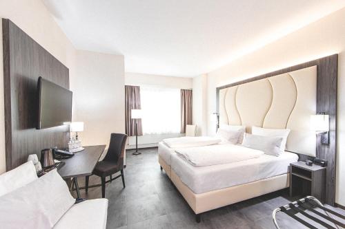 曼海姆Best Western Plaza Hotel Mannheim的酒店客房配有两张床和一张书桌