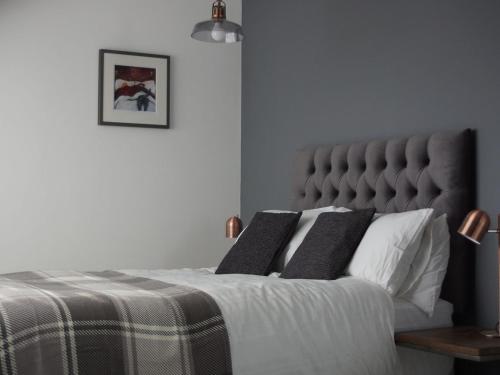 纽基Skyline Guesthouse的一间卧室配有一张带灰色床头板的床