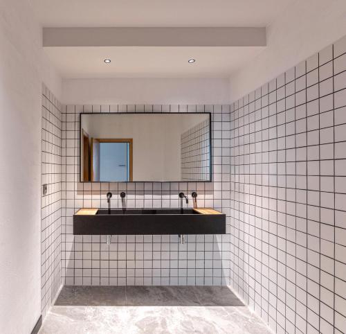 卢戈Hotel Forum Ceao的浴室设有白色瓷砖墙壁和镜子
