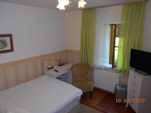 圣加伦罗伊德尔度假屋的一间卧室配有一张床、一张桌子和一把椅子
