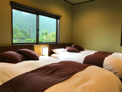 京都Ohara Sensui Surrounded by Beautiful Nature的带窗户的客房内的两张床