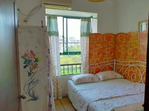 上海宜居民宿-闵行颛桥地铁站的一间卧室设有一张床和一个窗口