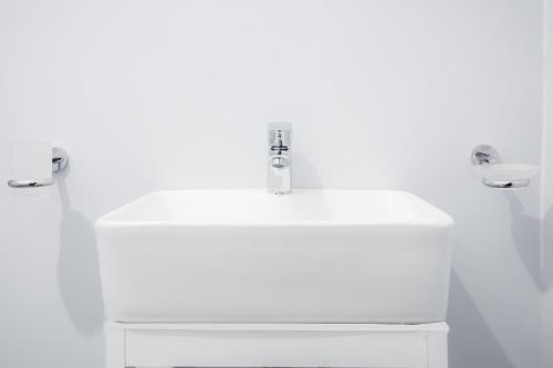 维勒珀图KAYJAY WILD WILPATTU的浴室水槽和白色墙壁上的两个水龙头