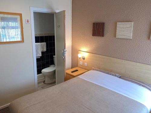 布莱克浦Grange House Hotel的一间卧室配有一张床,浴室设有卫生间