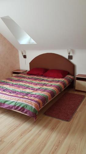 特尔希艾GRAŽINOS SODYBA的一间卧室配有一张带五颜六色棉被的床