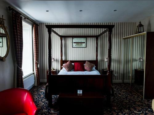 DonaghadeePier 36的一间卧室配有一张带红色枕头的天蓬床