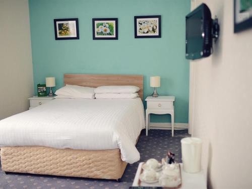 洛斯托夫特Park Hill Hotel的卧室配有一张白色的大床和两张桌子