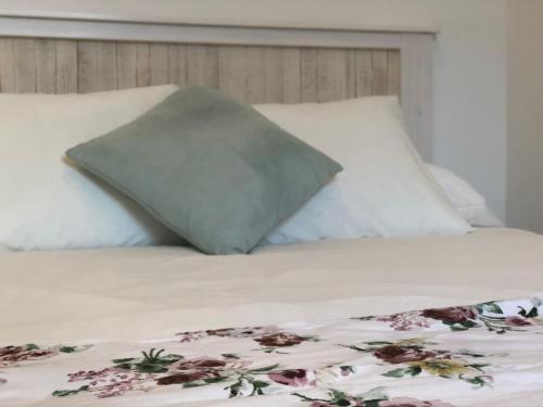克里斯托港Alma House的一张带两个枕头的床和一张带鲜花的毯子
