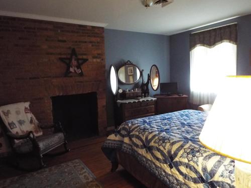 盖茨堡The Tillie Pierce House Inn的一间卧室配有一张床、一个壁炉和一个镜子