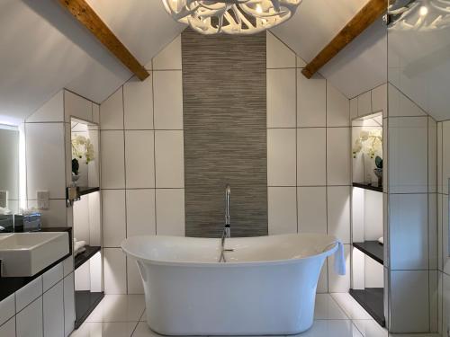 桑德巴奇The Wheatsheaf Hotel, Sandbach的白色的浴室设有浴缸和水槽。