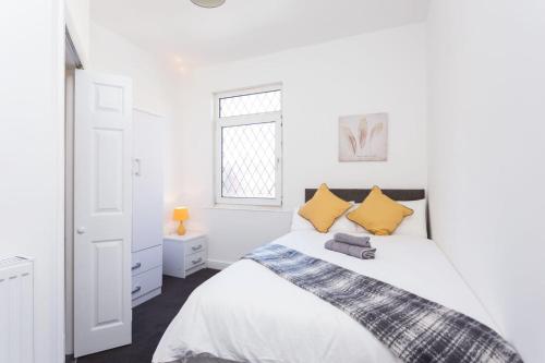特伦特河畔斯托克Townhouse @ 76 Clare Street Stoke的白色卧室配有一张带黄色枕头的大床