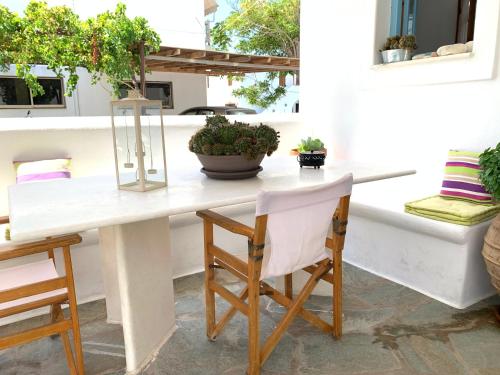 帕罗奇亚Rodia Studios & Apartments的种有植物的庭院里摆放着白色的桌椅