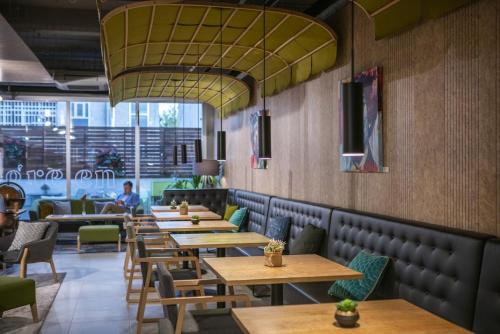 马德里ARTIEM Madrid的餐厅设有木桌和绿色椅子