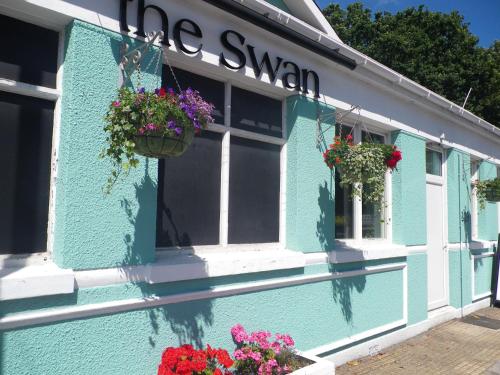 南安普敦The Swan Inn的蓝色的建筑,窗户上有鲜花