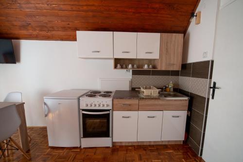 SurdulicaApartmani Sunčev breg Vlasinsko jezero的厨房配有白色橱柜和炉灶烤箱。