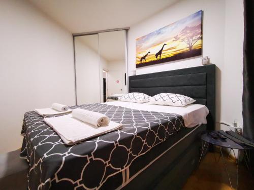 尼什Merkur Luxury Apartman的一间卧室配有一张大床和毛巾