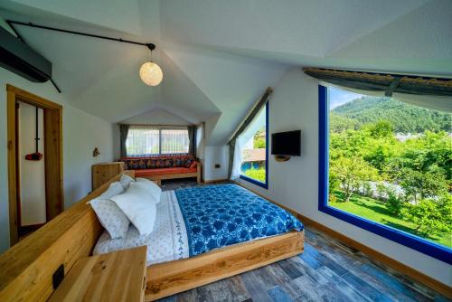 戈西克Only Blue Villa的一间卧室设有一张床和一个大窗户