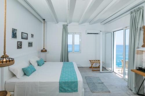 巴利恩Blue Bay Lifestyle - ex Bali Blue Bay的白色卧室配有一张带蓝色枕头的大床