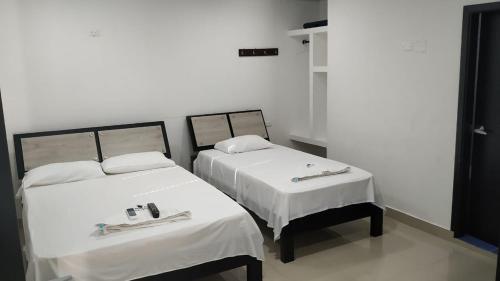 La Jagua de IbiricoHotel Jagua Real的配有白色床单的客房内的两张床