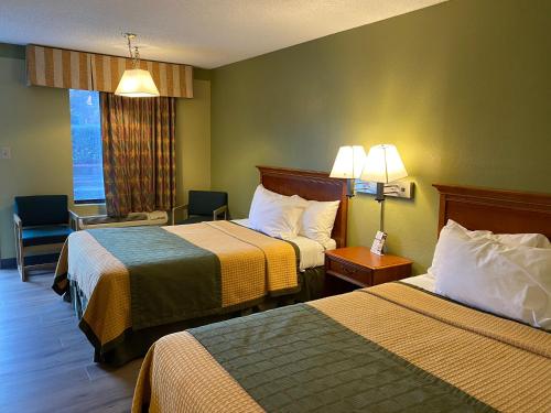 康科德Cabarrus Inn的酒店客房带两张床、椅子和窗户
