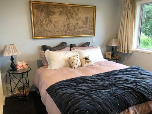 KelburnExecutive style bedroom的卧室配有带枕头的床铺和墙上的绘画