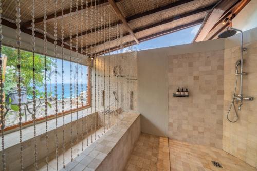 蓝梦岛Blue Lagoon Avia Villas的带淋浴的浴室和大窗户
