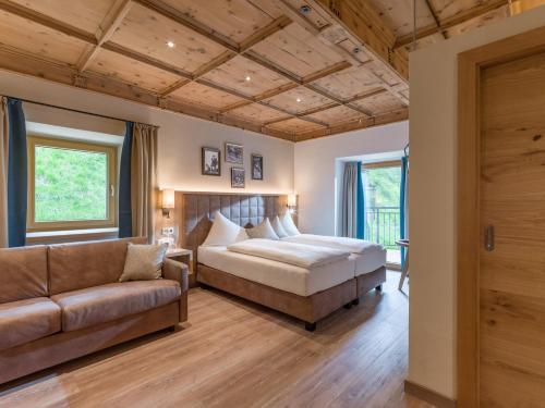 蒂罗尔-基希贝格Alpen Glück Hotel Unterm Rain garni的一间卧室配有一张床和一张沙发