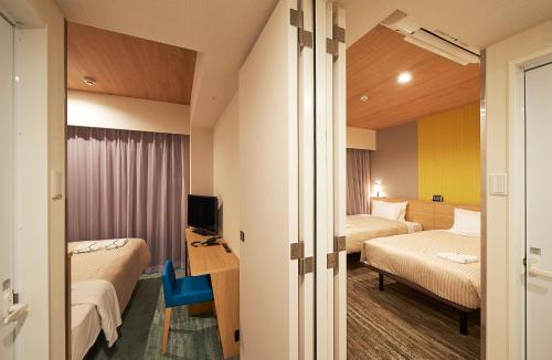 东京东京田町索特图斯弗雷撒酒店的酒店客房设有两张床和电视。