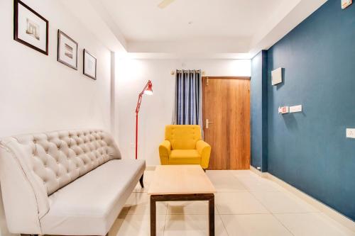 耶拉汉卡FabHotel The Sun Suites Vinayaka Nagar的带沙发和黄色椅子的客厅