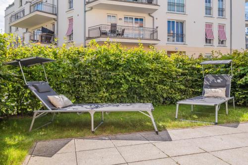 伯尔格伦德-雷特维施Villa Seeadler的两把椅子坐在建筑物前面的草上