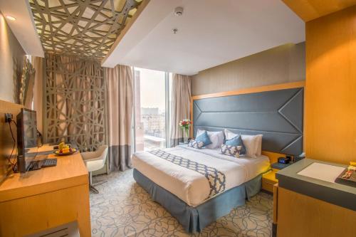 利雅德Grand Plaza Hotel - Gulf Riyadh的一间设有大床和窗户的酒店客房