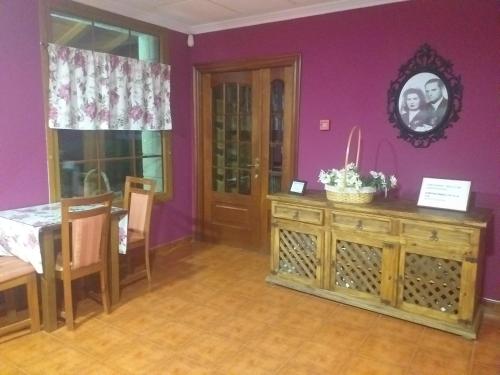 萨穆迪奥Hotel Artea Errota的一间设有一张桌子和紫色墙壁的用餐室