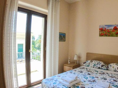 雷焦卡拉布里亚La Casa di Aurora的一间卧室设有一张床和一个滑动玻璃门