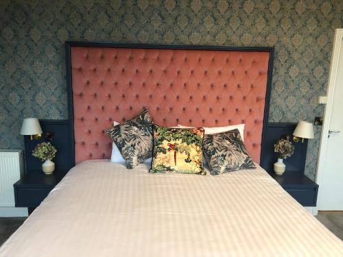 Cluain Eois克赖顿酒店 的一间卧室配有一张大床和红色床头板