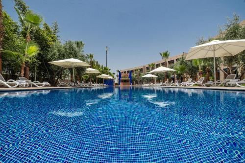 马拉喀什瓦佐酒店的一个带椅子和遮阳伞的大型蓝色游泳池