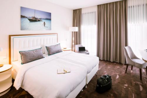 柏林柏林美居农业酒店的酒店客房设有一张白色大床和一张书桌