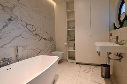 梅赫伦Nova Zembla的白色的浴室设有浴缸和水槽。