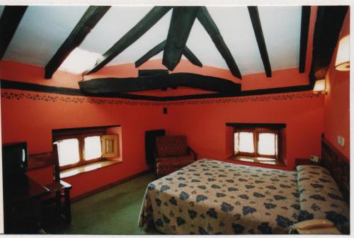 Ontaneda波萨达德尔帕斯酒店的卧室设有红色的墙壁、一张床和两个窗户