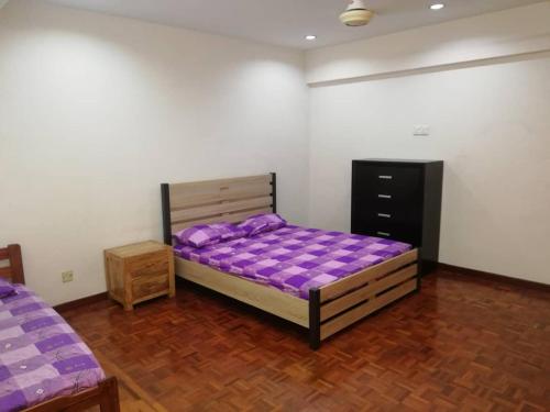 芙蓉Sweethome for 7 travellers at seremban的一间卧室配有一张紫色的床,铺有木地板
