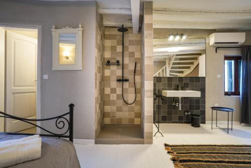罗维尼Deluxe Apartment Casa Flores with Sea View & Terrace的带淋浴的浴室和客房内的一张床