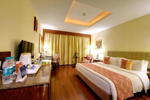 班加罗尔Fortune Select JP Cosmos, Bengaluru - Member ITC's hotel group的酒店客房设有一张大床和一张书桌。